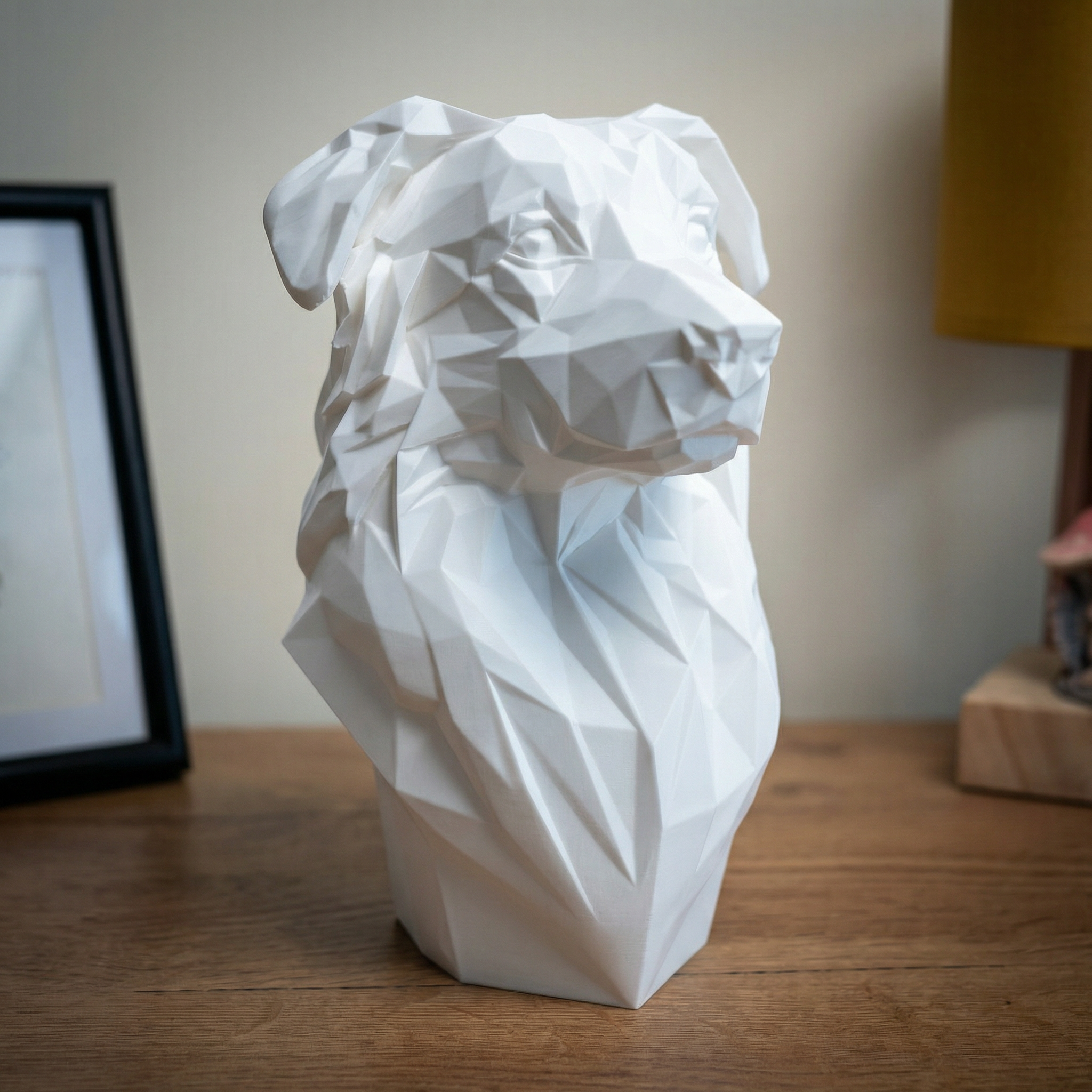 White geometric dog sculpture on a wooden surface with a blurred background

